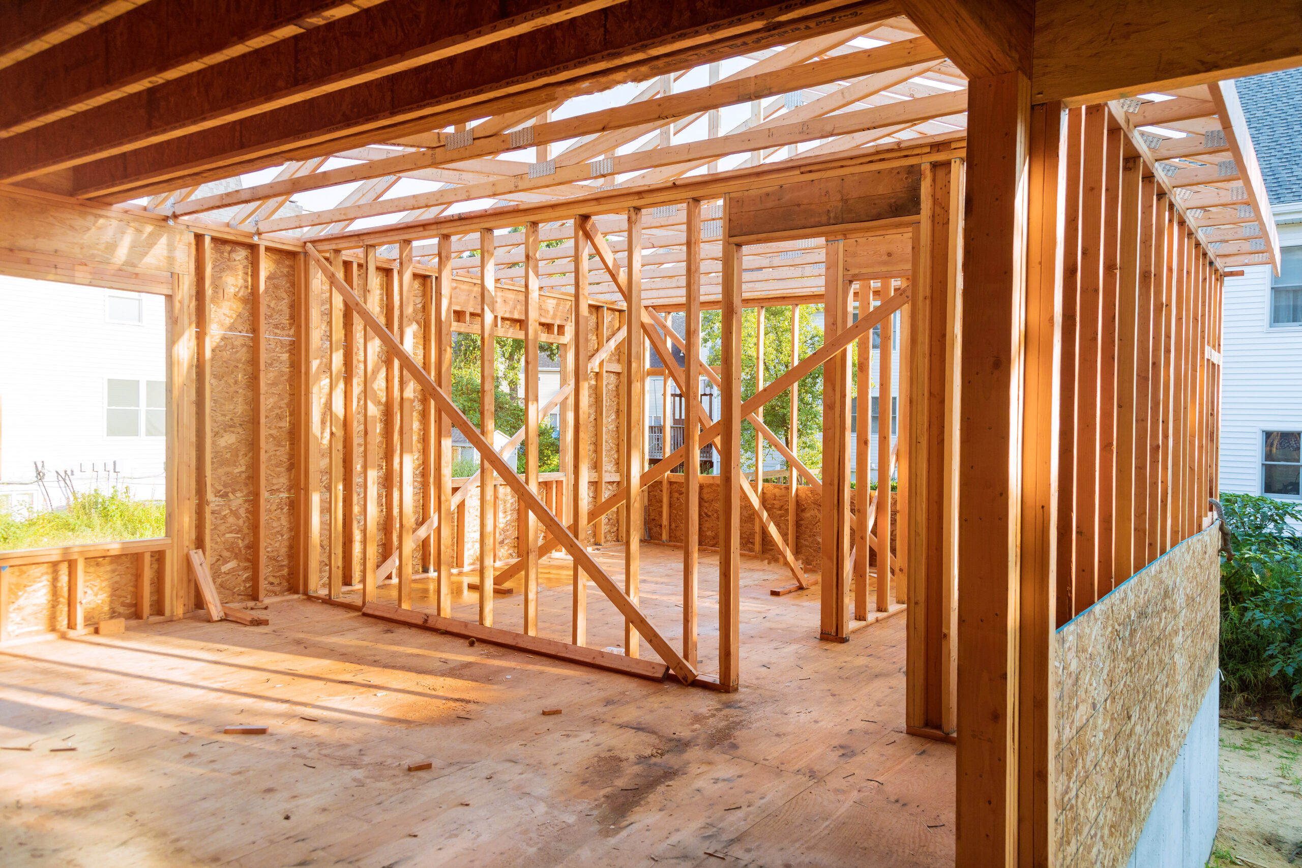 Building construction, wood framing new home under construction roof being built against blue sky