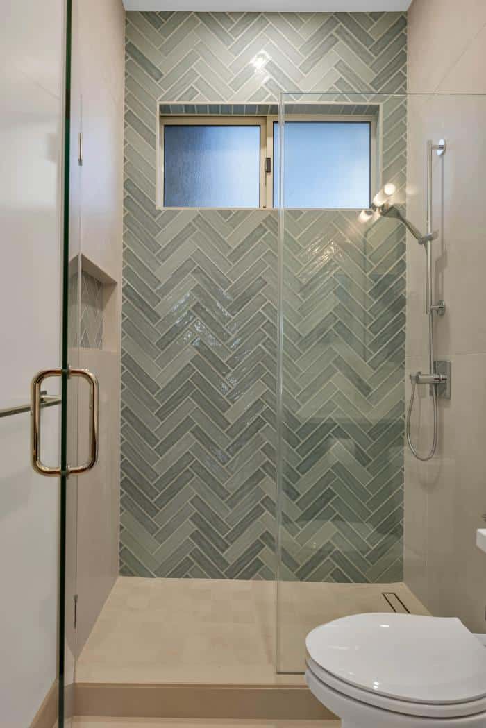 Stanford guest bathroom — sage herringbone shower with brass handle