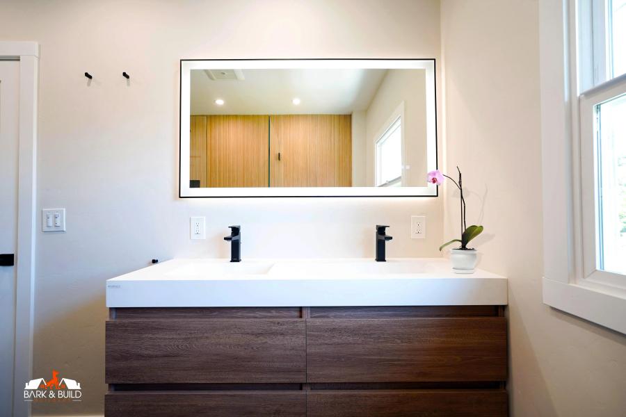 Belmont master bathroom — floating walnut vanity and backlit mirror
