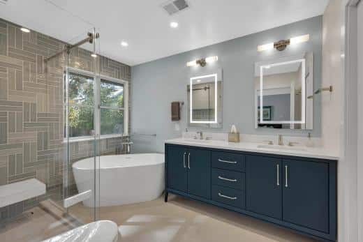 Stanford master bath — navy vanity and freestanding tub