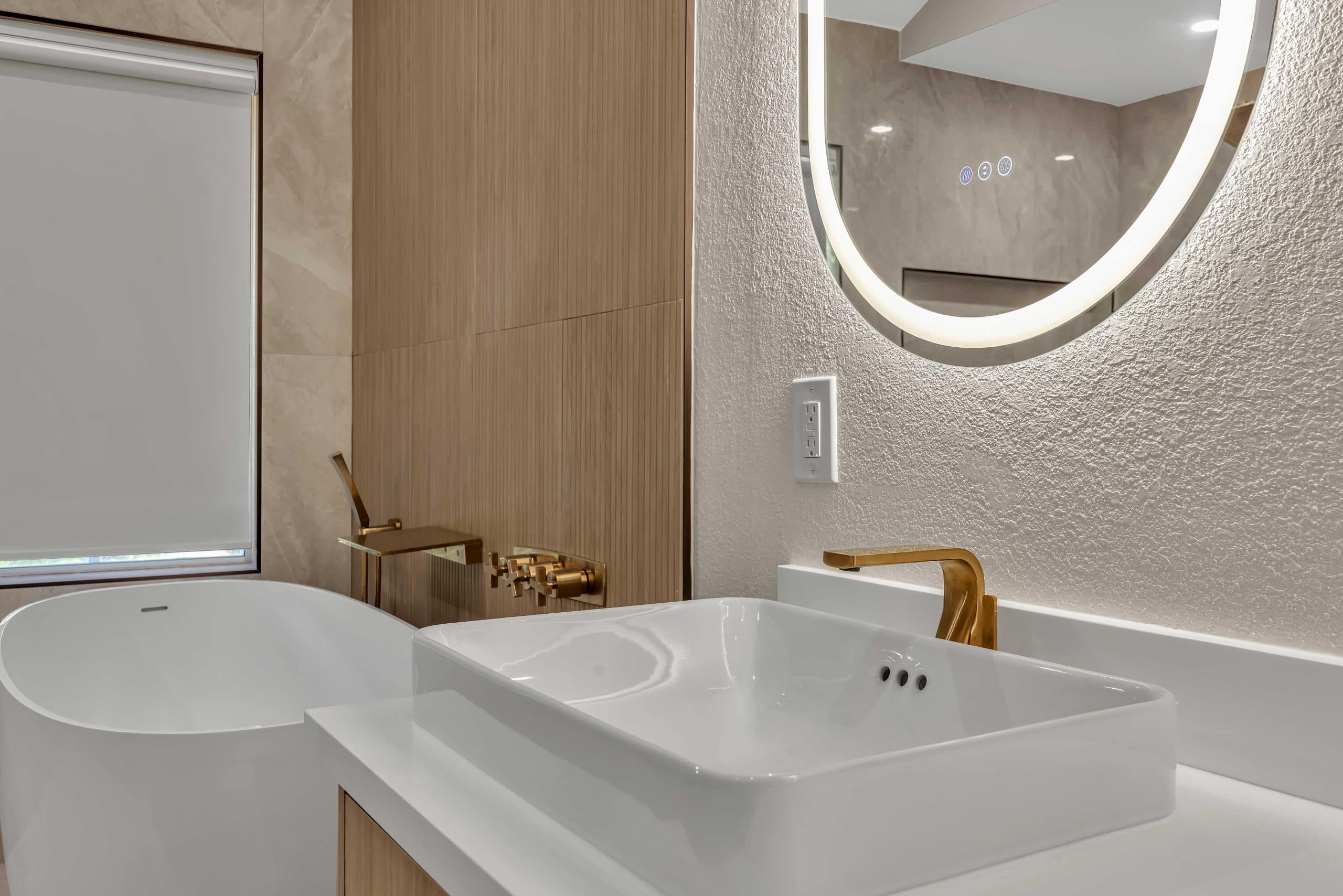 Pleasanton master bathroom — white vessel sink with brushed-gold faucet and round LED mirror