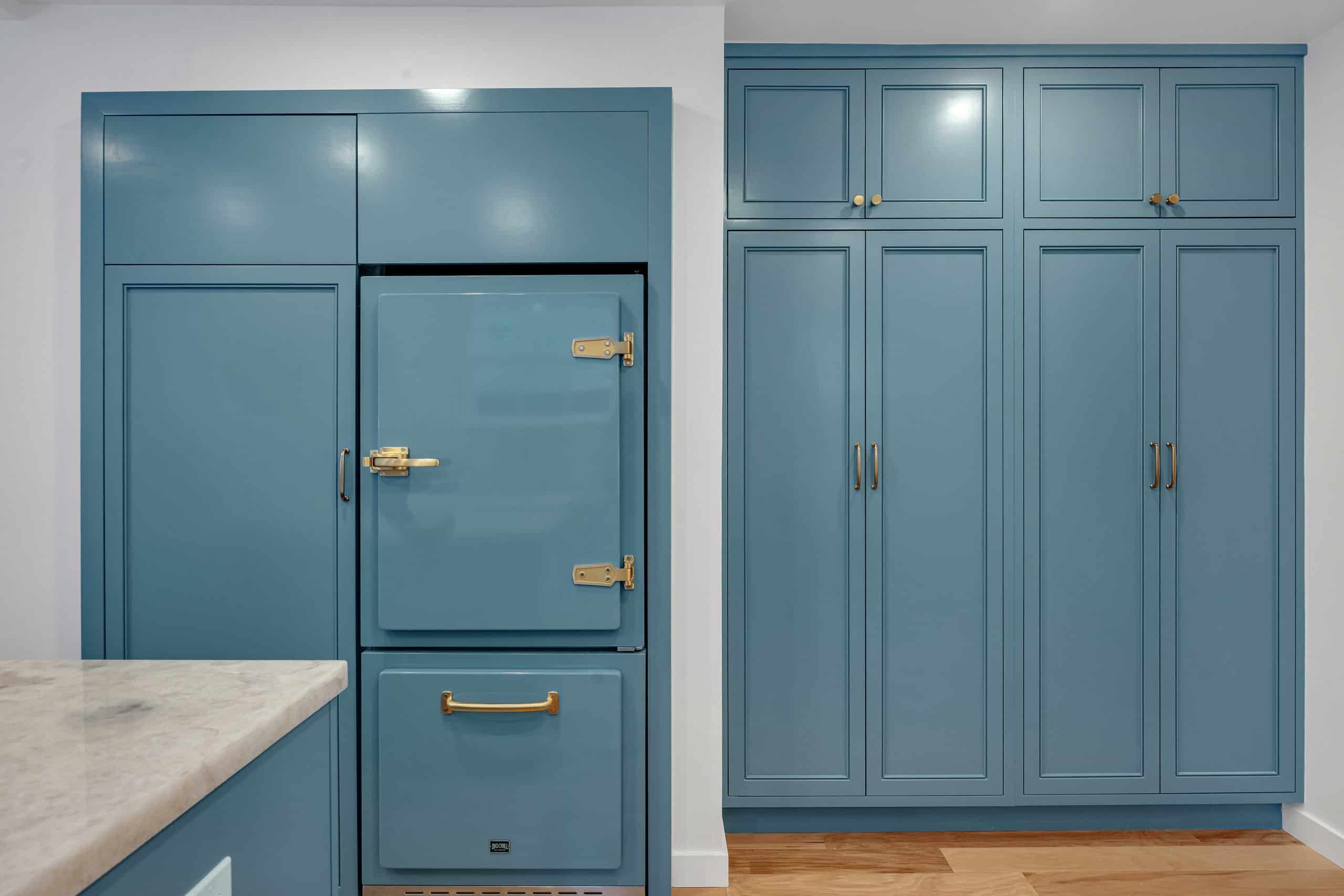 Menlo Park kitchen — teal vintage-style refrigerator with brass latch hinges beside floor-to-ceiling blue pantry cabinets
