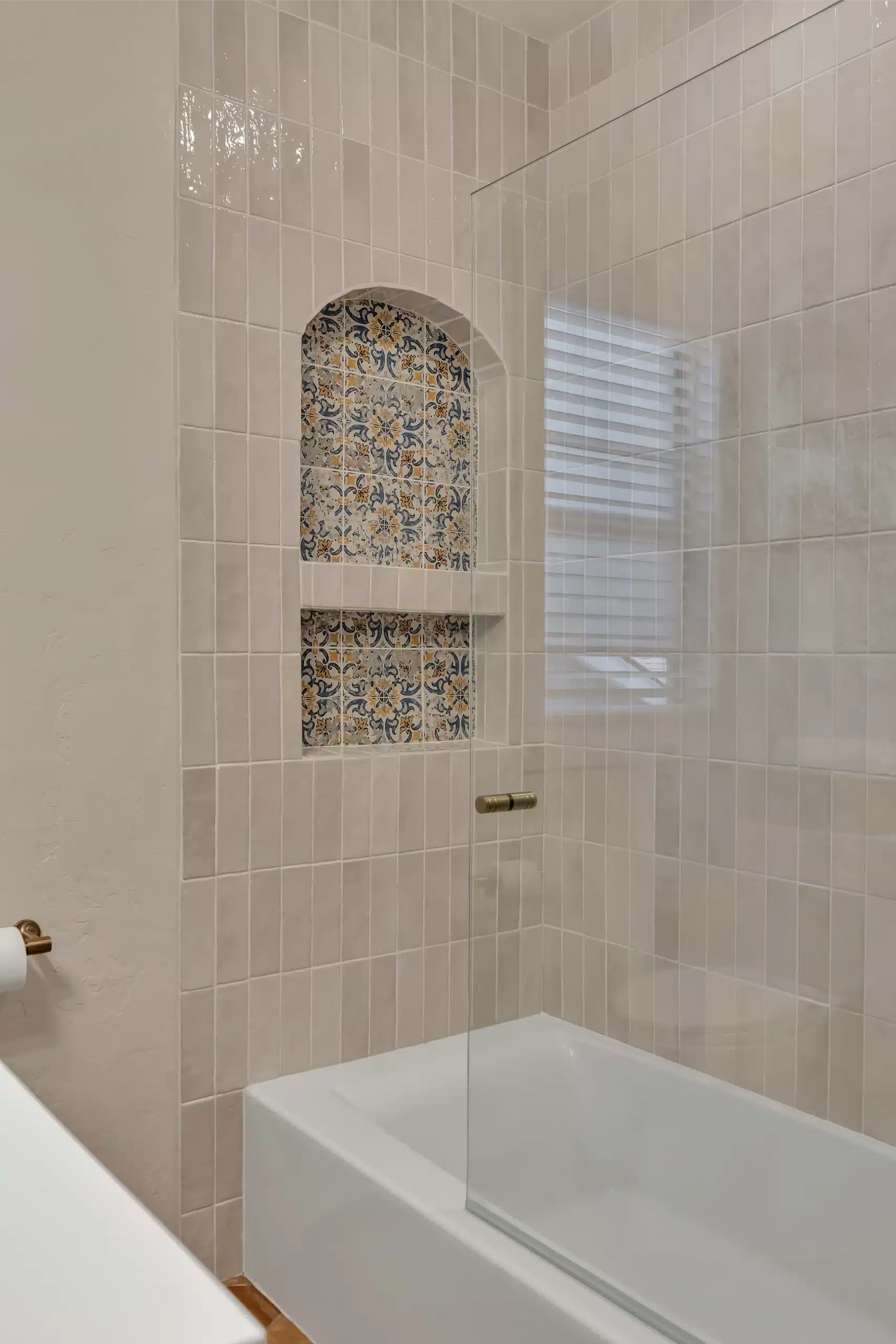 Tub surround with a full-height arched niche finished in patterned tile